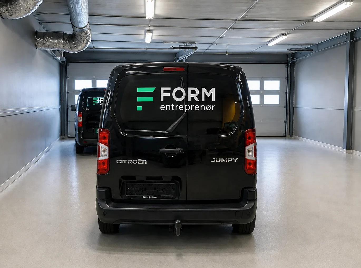 Bildekor med FORM Entreprenør-logo på sort varebil
